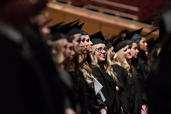 Graduates stand as they are recognized for their accomplishments.