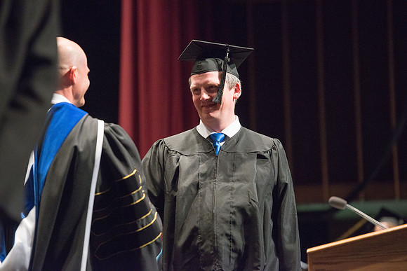 Convocation for College of Physical Sciences and Engineering in the Hart Auditorium.  Graduates receive their diploma covers.