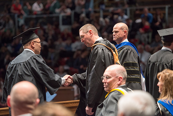 Convocation for College of Physical Sciences and Engineering in the Hart Auditorium.  Graduates receive their diploma covers.