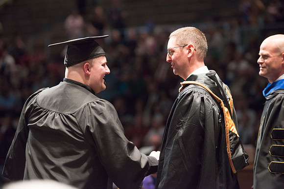 Convocation for College of Physical Sciences and Engineering in the Hart Auditorium.  Graduates receive their diploma covers.
