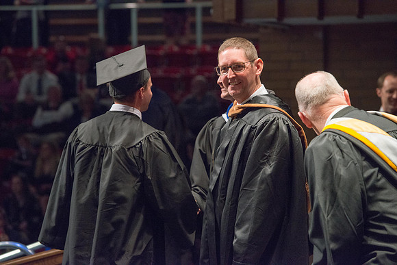 Convocation for College of Physical Sciences and Engineering in the Hart Auditorium.  Graduates receive their diploma covers.