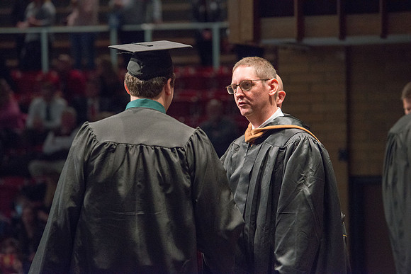 Convocation for College of Physical Sciences and Engineering in the Hart Auditorium.  Graduates receive their diploma covers.