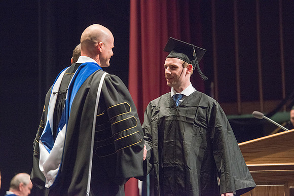 Convocation for College of Physical Sciences and Engineering in the Hart Auditorium.  Graduates receive their diploma covers.