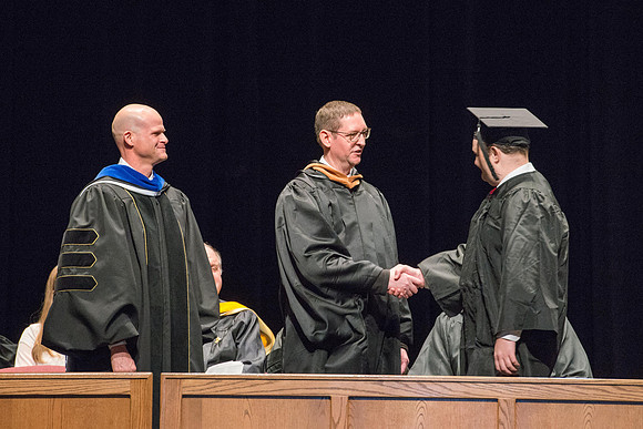 Convocation for College of Physical Sciences and Engineering in the Hart Auditorium.  Graduates receive their diploma covers.