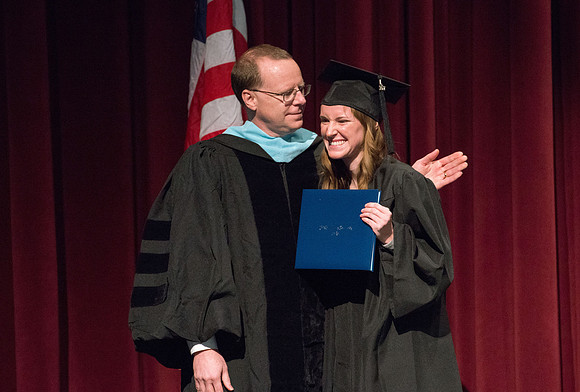 Convocation for College of Physical Sciences and Engineering in the Hart Auditorium.  Graduates receive their diploma covers.