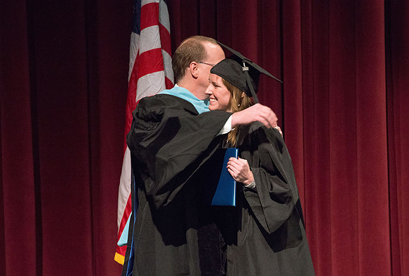 Convocation for College of Physical Sciences and Engineering in the Hart Auditorium.  Graduates receive their diploma covers.