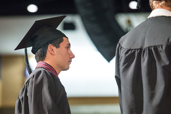 Convocation for College of Physical Sciences and Engineering in the Hart Auditorium.  Graduates receive their diploma covers.