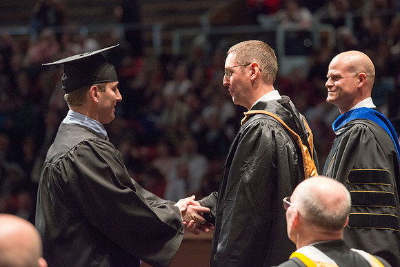 Convocation for College of Physical Sciences and Engineering in the Hart Auditorium.  Graduates receive their diploma covers.