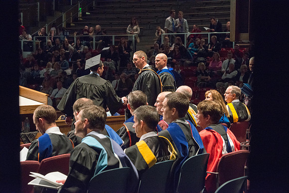Convocation for College of Physical Sciences and Engineering in the Hart Auditorium.  Graduates receive their diploma covers.