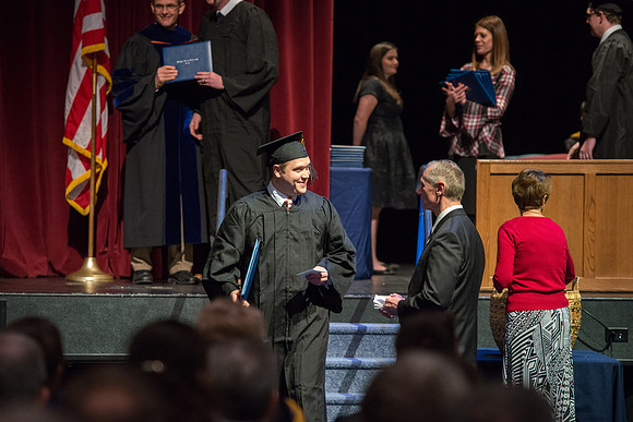 Convocation for College of Physical Sciences and Engineering in the Hart Auditorium.  Graduates receive their diploma covers.