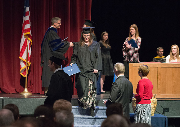 Convocation for College of Physical Sciences and Engineering in the Hart Auditorium.  Graduates receive their diploma covers.