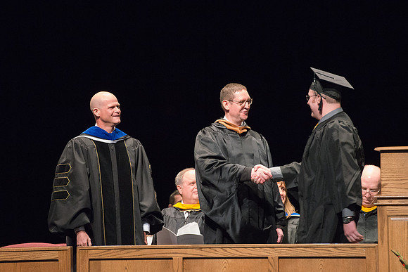 Convocation for College of Physical Sciences and Engineering in the Hart Auditorium.  Graduates receive their diploma covers.