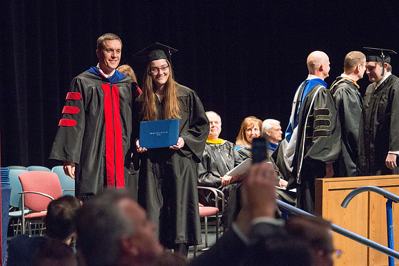 Convocation for College of Physical Sciences and Engineering in the Hart Auditorium.  Graduates receive their diploma covers.
