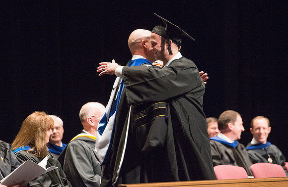 Convocation for College of Physical Sciences and Engineering in the Hart Auditorium.  Graduates receive their diploma covers.