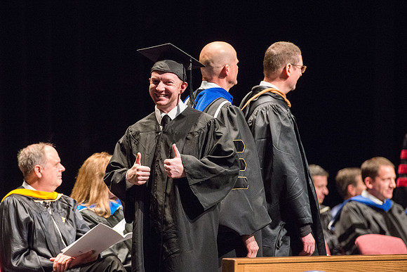 Convocation for College of Physical Sciences and Engineering in the Hart Auditorium.  Graduates receive their diploma covers.
