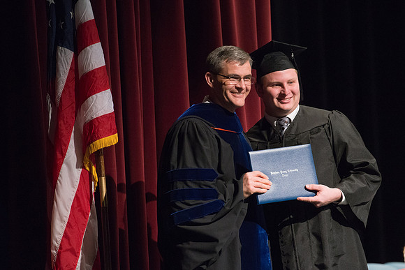 Convocation for College of Physical Sciences and Engineering in the Hart Auditorium.  Graduates receive their diploma covers.