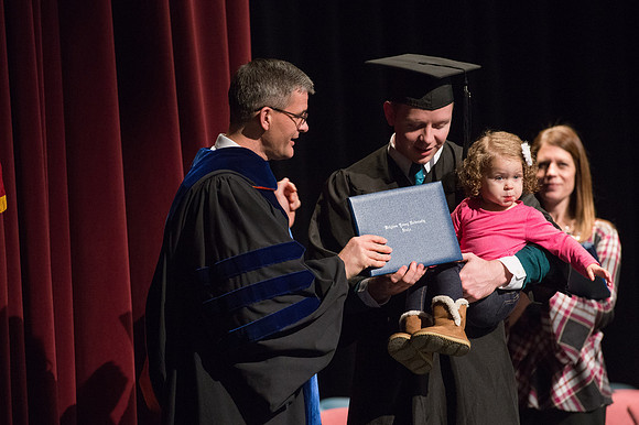 Convocation for College of Physical Sciences and Engineering in the Hart Auditorium.  Graduates receive their diploma covers.