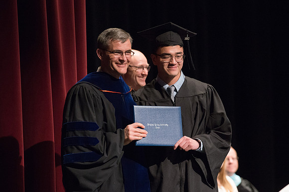 Convocation for College of Physical Sciences and Engineering in the Hart Auditorium.  Graduates receive their diploma covers.