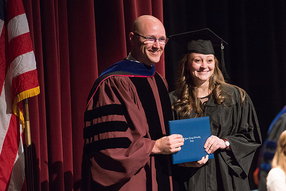 Convocation for College of Physical Sciences and Engineering in the Hart Auditorium.  Graduates receive their diploma covers.