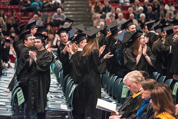 Convocation for College of Physical Sciences and Engineering in the Hart Auditorium.  Graduates receive their diploma covers.