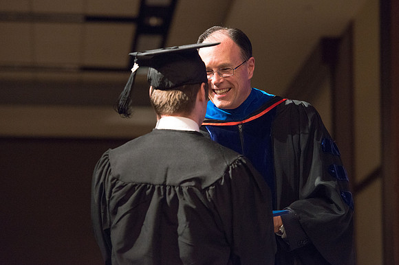 Convocation for College of Language and Letters.  Bishop W. Christopher Waddell and President Henry J Eyring present the graduates with their diploma covers.