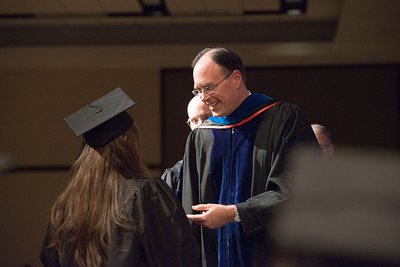 Convocation for College of Language and Letters.  Bishop W. Christopher Waddell and President Henry J Eyring present the graduates with their diploma covers.