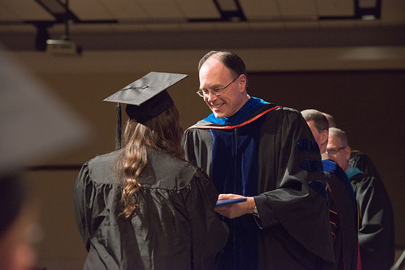 Convocation for College of Language and Letters.  Bishop W. Christopher Waddell and President Henry J Eyring present the graduates with their diploma covers.