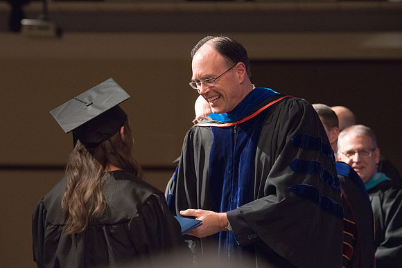 Convocation for College of Language and Letters.  Bishop W. Christopher Waddell and President Henry J Eyring present the graduates with their diploma covers.
