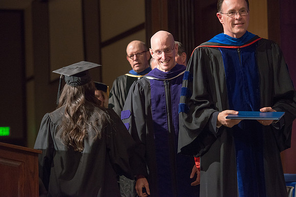 Convocation for College of Language and Letters.  Bishop W. Christopher Waddell and President Henry J Eyring present the graduates with their diploma covers.