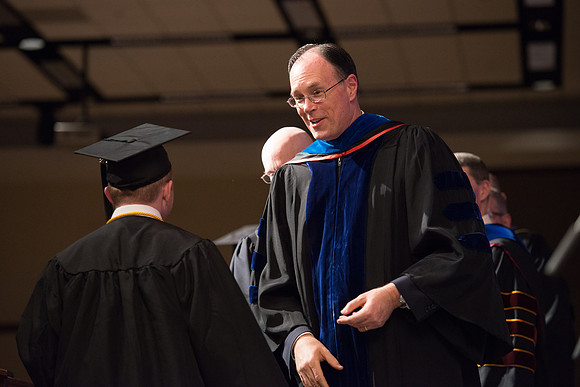 Convocation for College of Language and Letters.  Bishop W. Christopher Waddell and President Henry J Eyring present the graduates with their diploma covers.