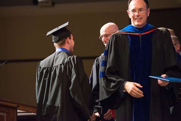 Convocation for College of Language and Letters.  Bishop W. Christopher Waddell and President Henry J Eyring present the graduates with their diploma covers.
