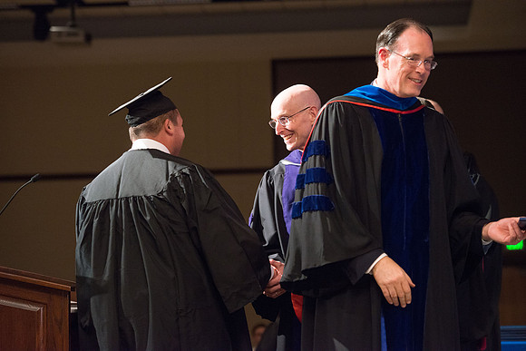 Convocation for College of Language and Letters.  Bishop W. Christopher Waddell and President Henry J Eyring present the graduates with their diploma covers.