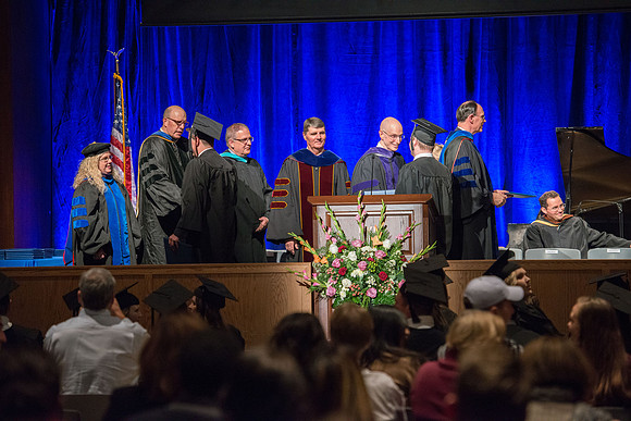 Convocation for College of Language and Letters.  Bishop W. Christopher Waddell and President Henry J Eyring present the graduates with their diploma covers.