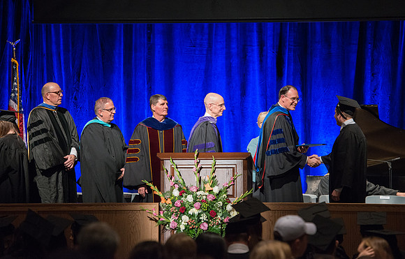 Convocation for College of Language and Letters.  Bishop W. Christopher Waddell and President Henry J Eyring present the graduates with their diploma covers.