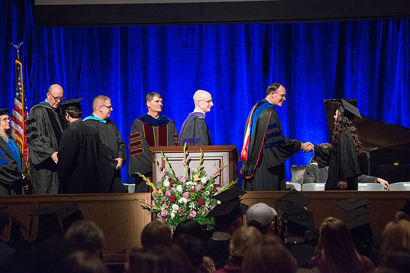 Convocation for College of Language and Letters.  Bishop W. Christopher Waddell and President Henry J Eyring present the graduates with their diploma covers.