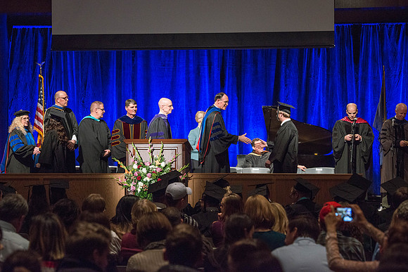 Convocation for College of Language and Letters.  Bishop W. Christopher Waddell and President Henry J Eyring present the graduates with their diploma covers.