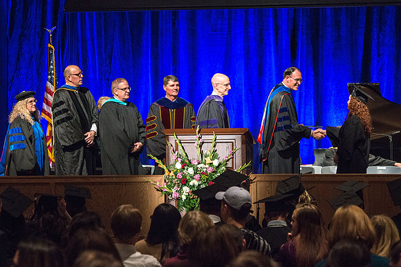 Convocation for College of Language and Letters.  Bishop W. Christopher Waddell and President Henry J Eyring present the graduates with their diploma covers.