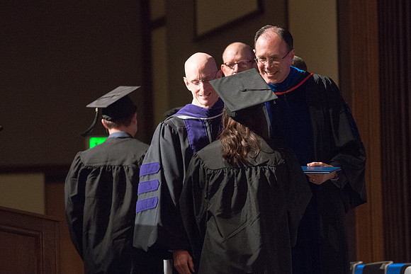 Convocation for College of Language and Letters.  Bishop W. Christopher Waddell and President Henry J Eyring present the graduates with their diploma covers.