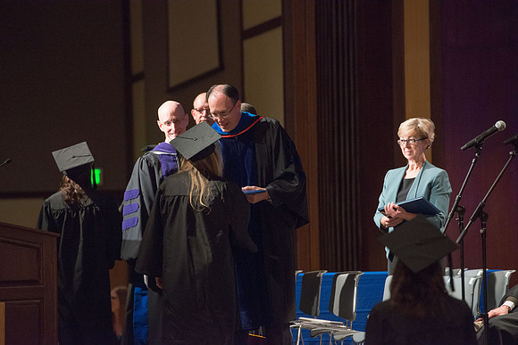 Convocation for College of Language and Letters.  Bishop W. Christopher Waddell and President Henry J Eyring present the graduates with their diploma covers.