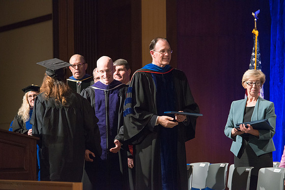 Convocation for College of Language and Letters.  Bishop W. Christopher Waddell and President Henry J Eyring present the graduates with their diploma covers.