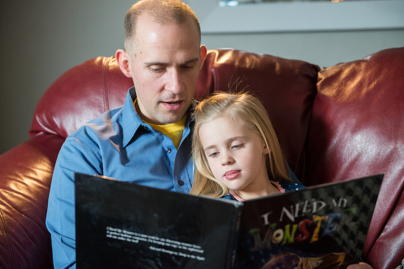 Adam reading to his daughter, "I Need My Monster".