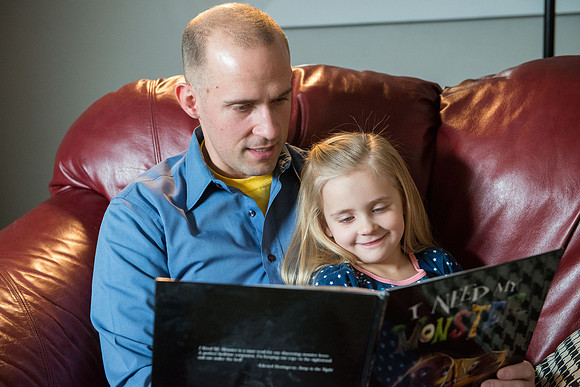Adam reading to his daughter, "I Need My Monster".