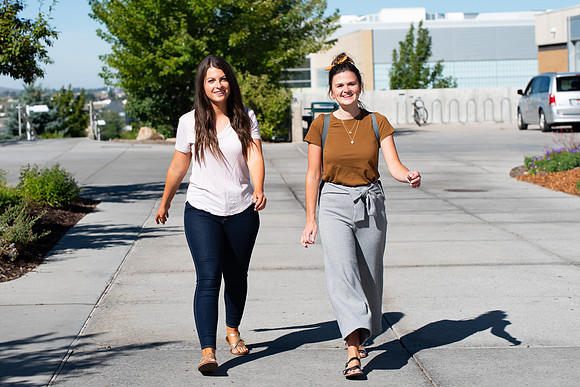 Examples of students staying safe and healthy during the COVID-19 pandemic by social distancing, following pathway arrows, and wearing face masks.