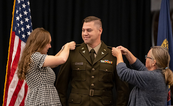Four graduates from the BYU-Idaho ROTC program gather with the families and have a ceremonial commissioning.
