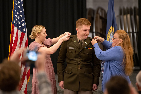Four graduates from the BYU-Idaho ROTC program gather with the families and have a ceremonial commissioning.