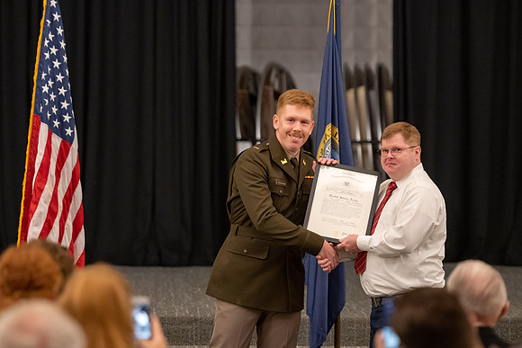 Four graduates from the BYU-Idaho ROTC program gather with the families and have a ceremonial commissioning.