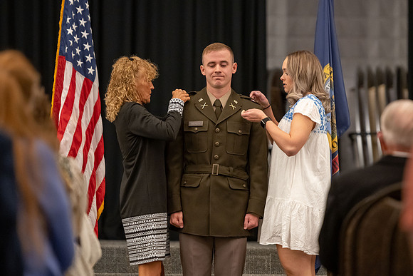 Four graduates from the BYU-Idaho ROTC program gather with the families and have a ceremonial commissioning.