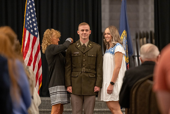 Four graduates from the BYU-Idaho ROTC program gather with the families and have a ceremonial commissioning.