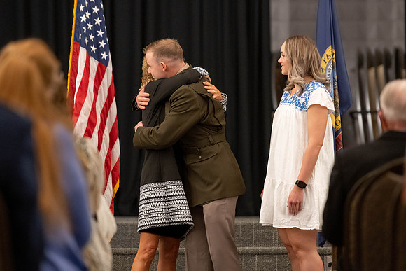 Four graduates from the BYU-Idaho ROTC program gather with the families and have a ceremonial commissioning.