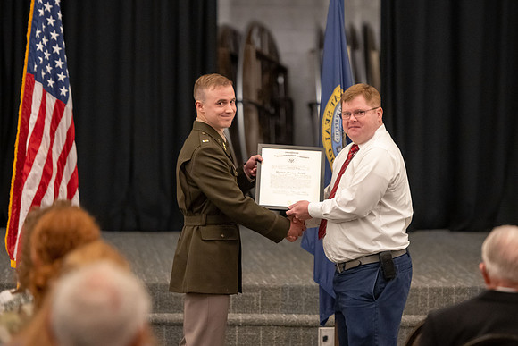 Four graduates from the BYU-Idaho ROTC program gather with the families and have a ceremonial commissioning.
